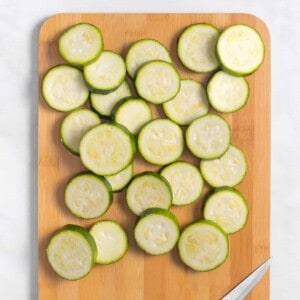 Zucchini rounds on a wooden cutting board.