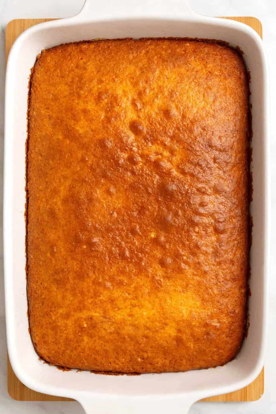 Golden brown baked pineapple upside down cake in baking dish. 