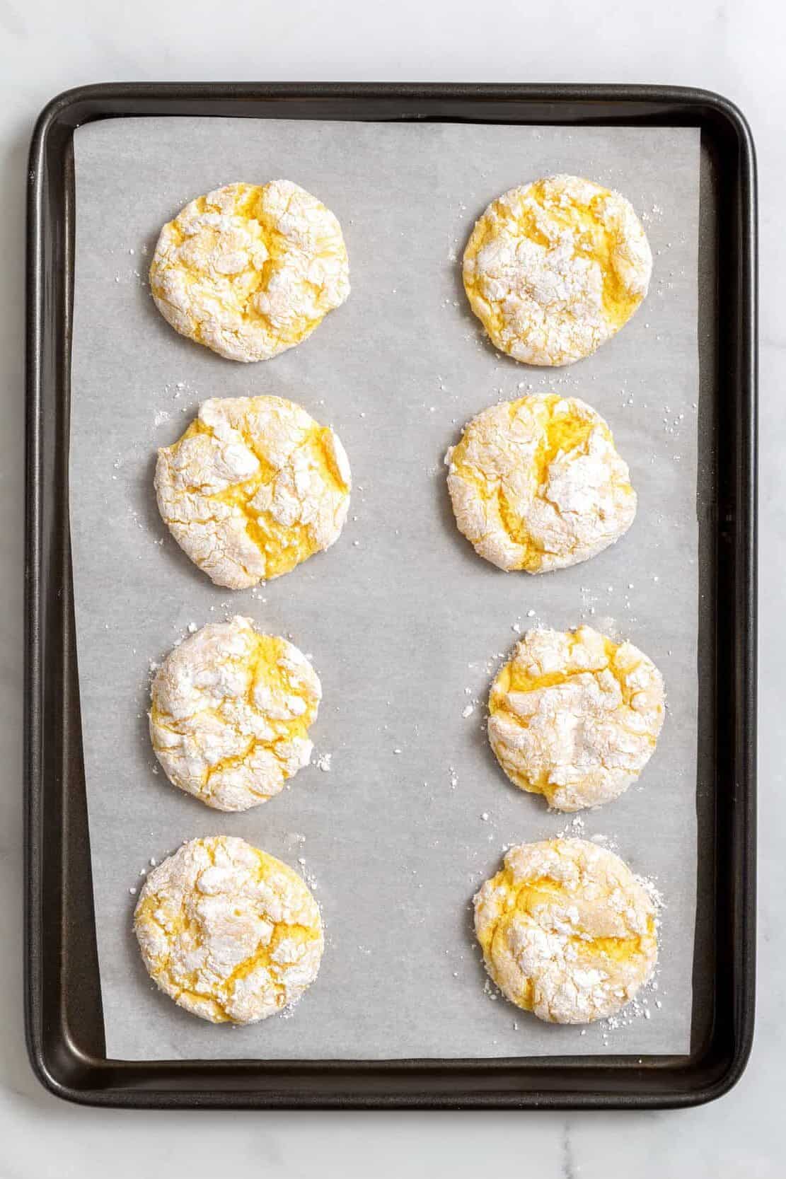 top down Image of baked Cool Whip cake mix, cookies sitting on a parchment lined baking tray.