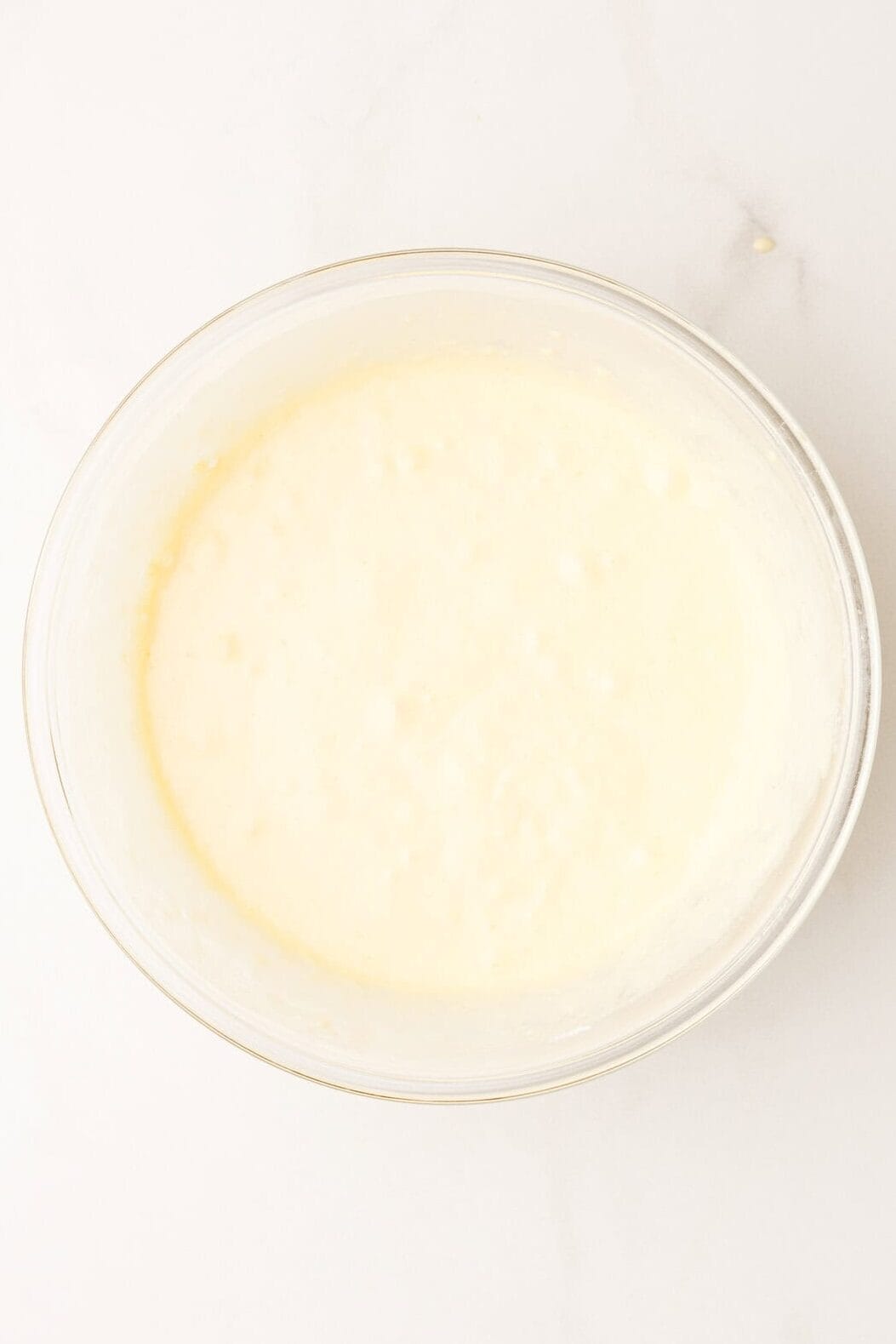 Top of a glass mixing bowl with pancake batter.