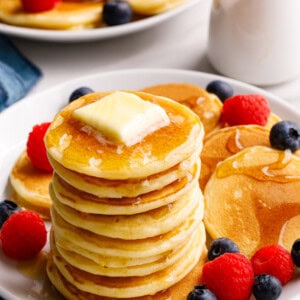 A stack of silver dollar pancakes topped with butter and syrup.