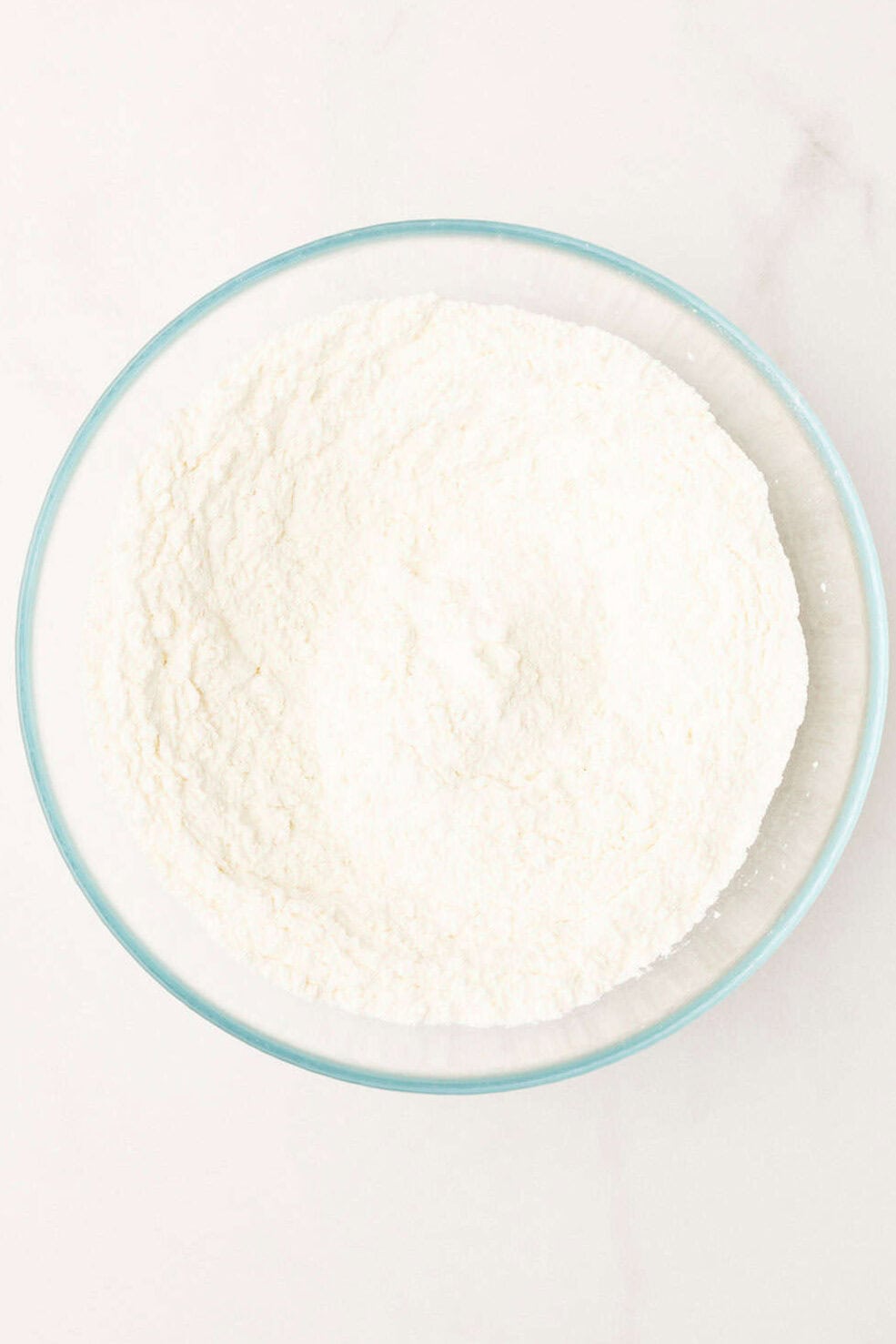 Dry ingredients mixed in a glass mixing bowl for silver dollar pancakes. 