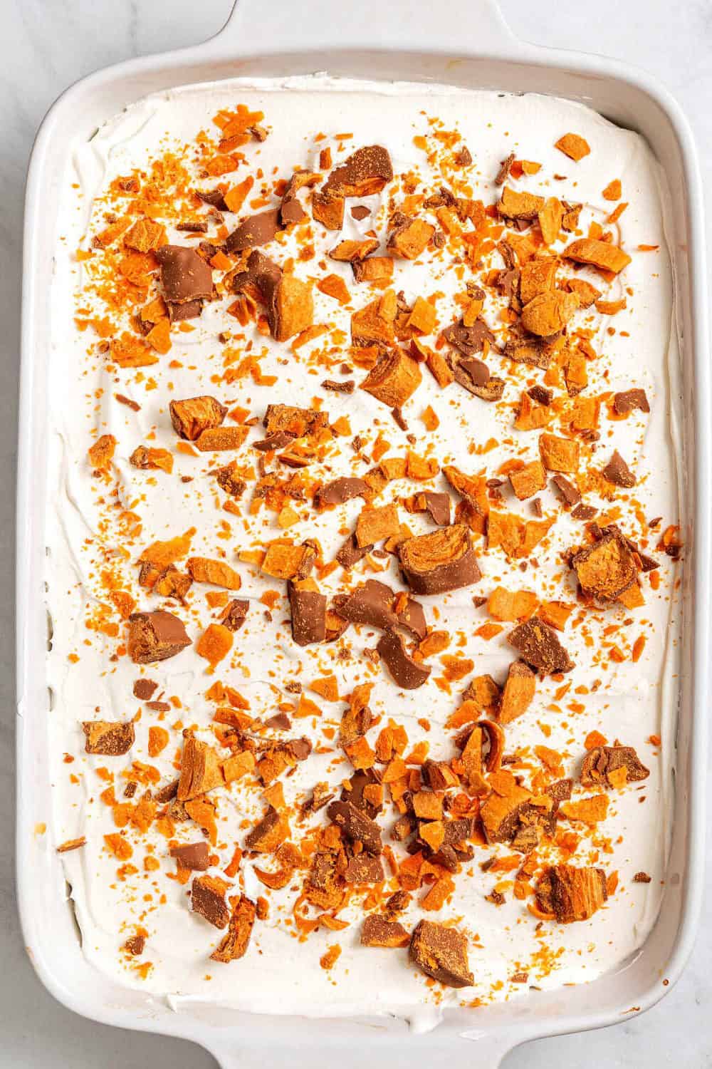 Image of buttercream poke cake in a 9 x 13 casserole baking dish.