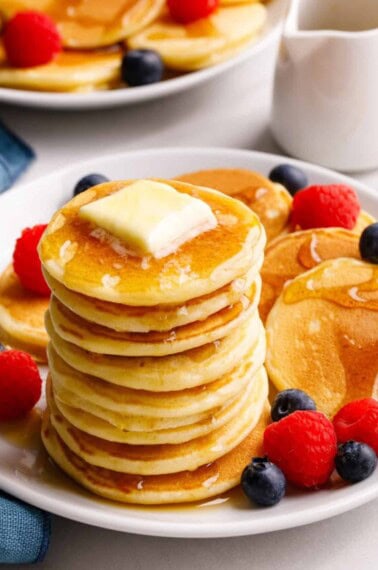 A stack of silver dollar pancakes topped with butter and syrup.