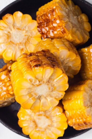 Grilled corn cob pieces in a cast iron skillet.