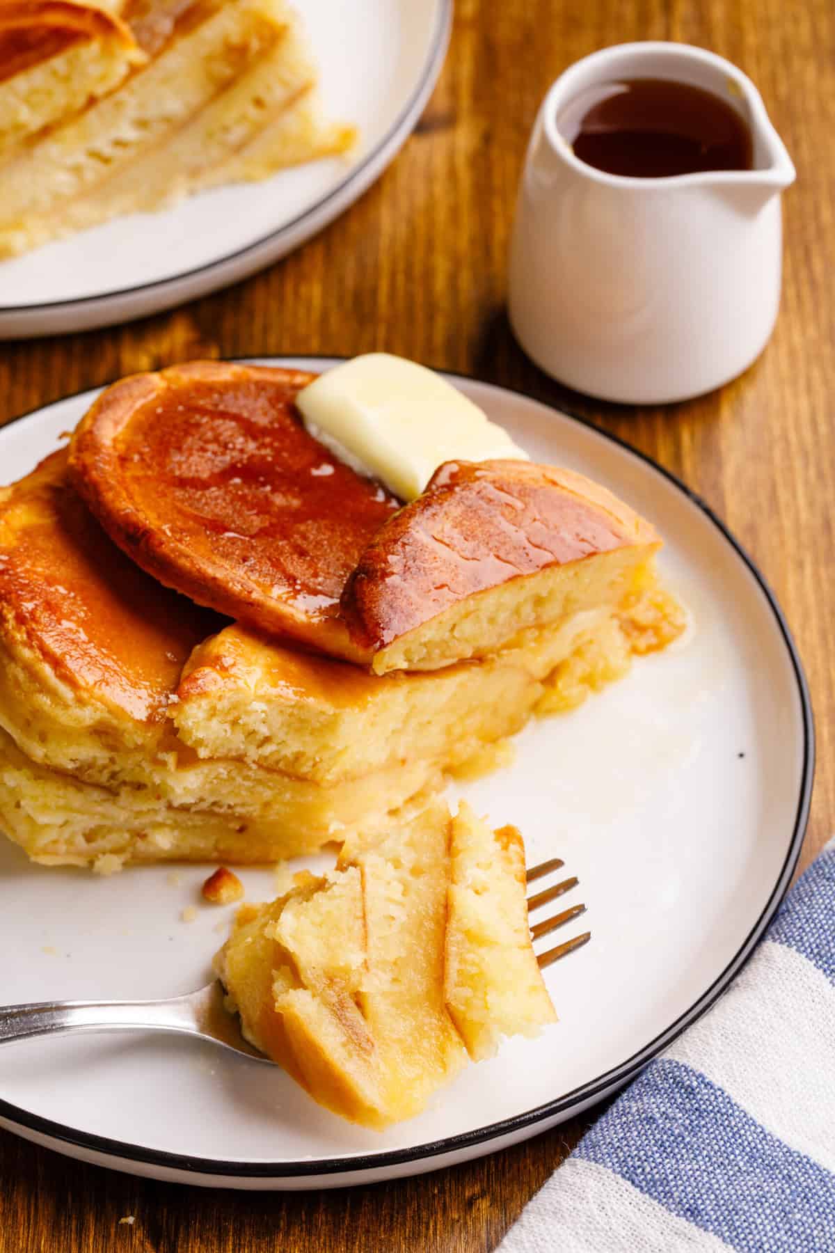 Close-up cross-section of a serving of overnight, pancake casserole sitting on a white round plate.