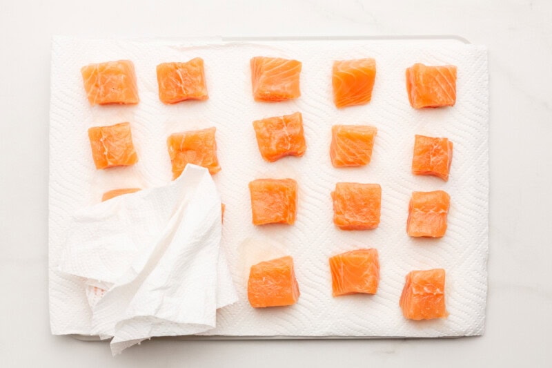 Salmon cubes being pat dry.
