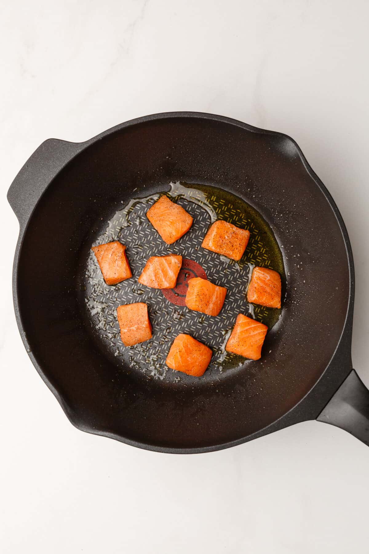 Salmon added to skillet with oil