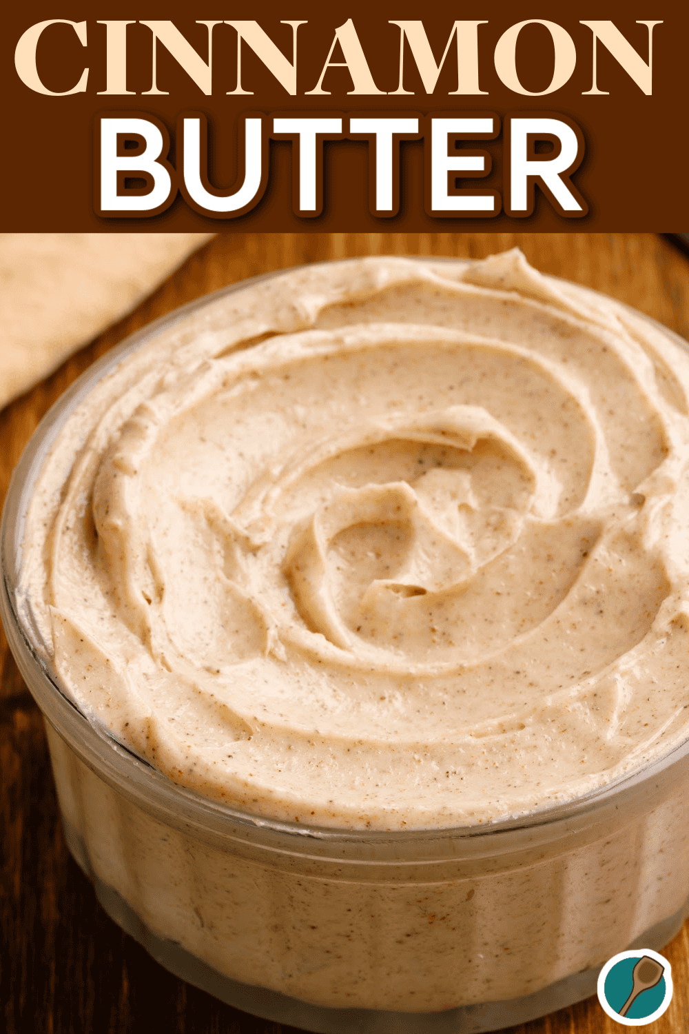 A glass dish filled with creamy homemade cinnamon butter, showcasing a swirl of rich texture with specks of cinnamon. This sweet and spiced spread, made with butter, powdered sugar, honey, and vanilla, is perfect for spreading on rolls, pancakes, or cornbread, adding a delicious touch to both sweet and savory dishes.