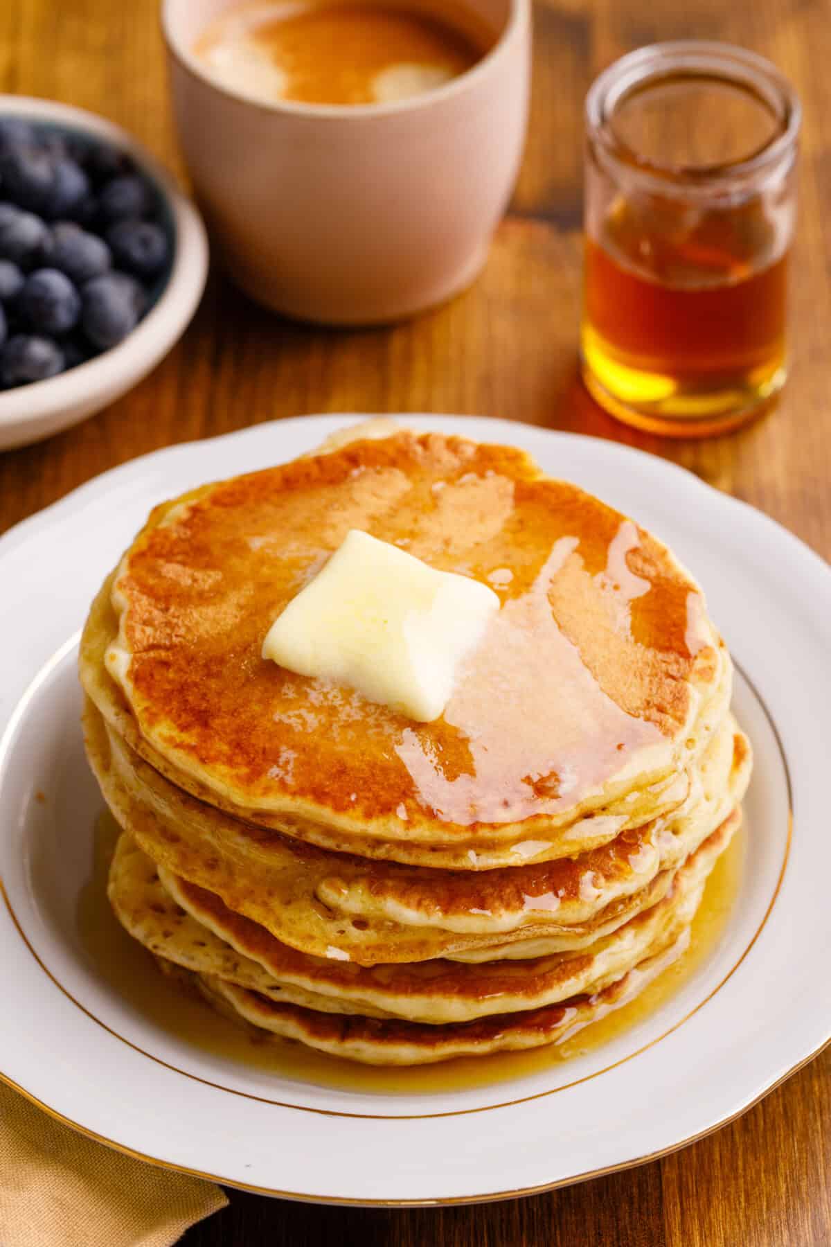 stack of pancakes with butter and syrup on top.