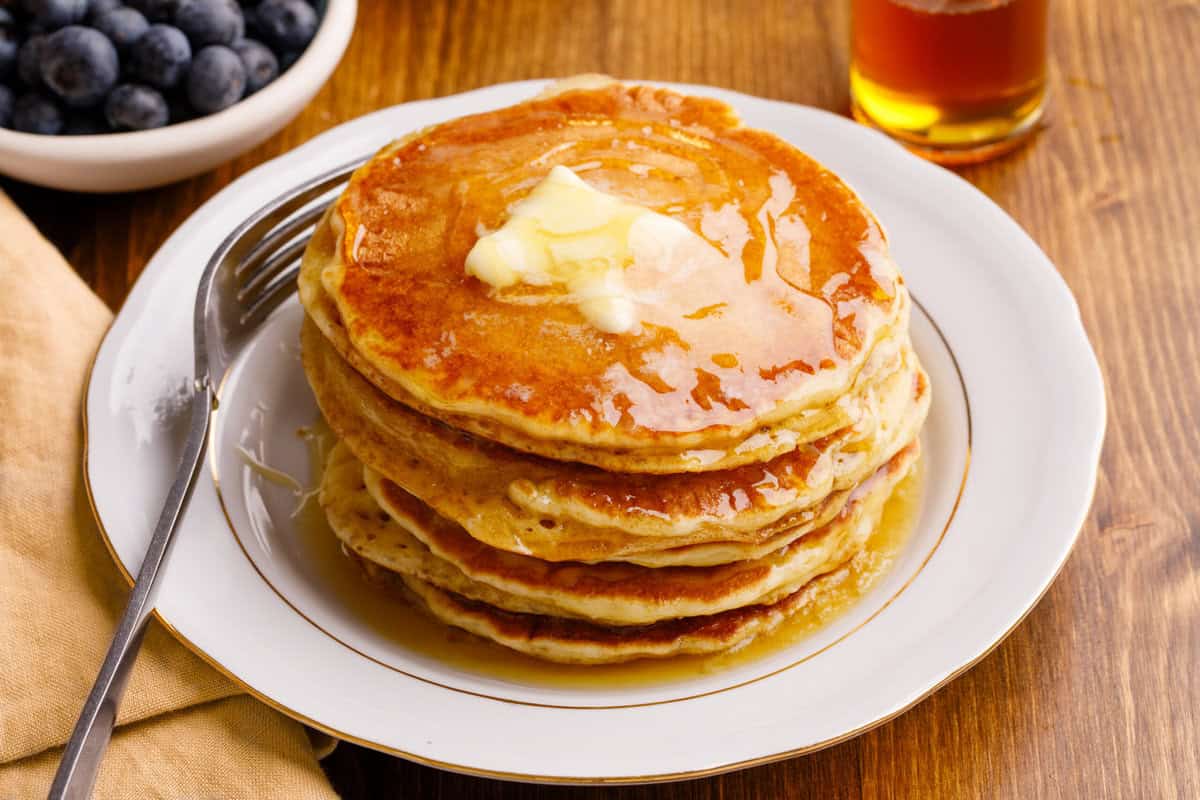 Stack of pancakes with butter and syrup.