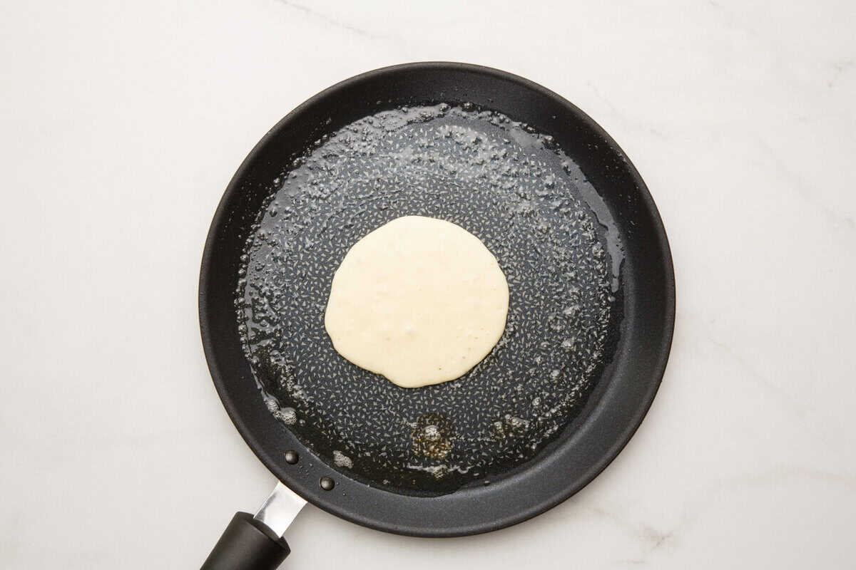 Pancake batter cooking in a skillet.