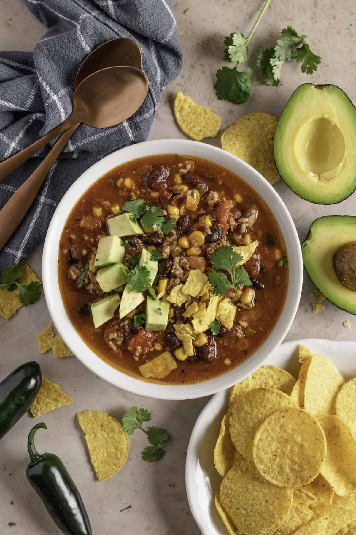 Top down image of bowl of taco soup with tortilla chips.