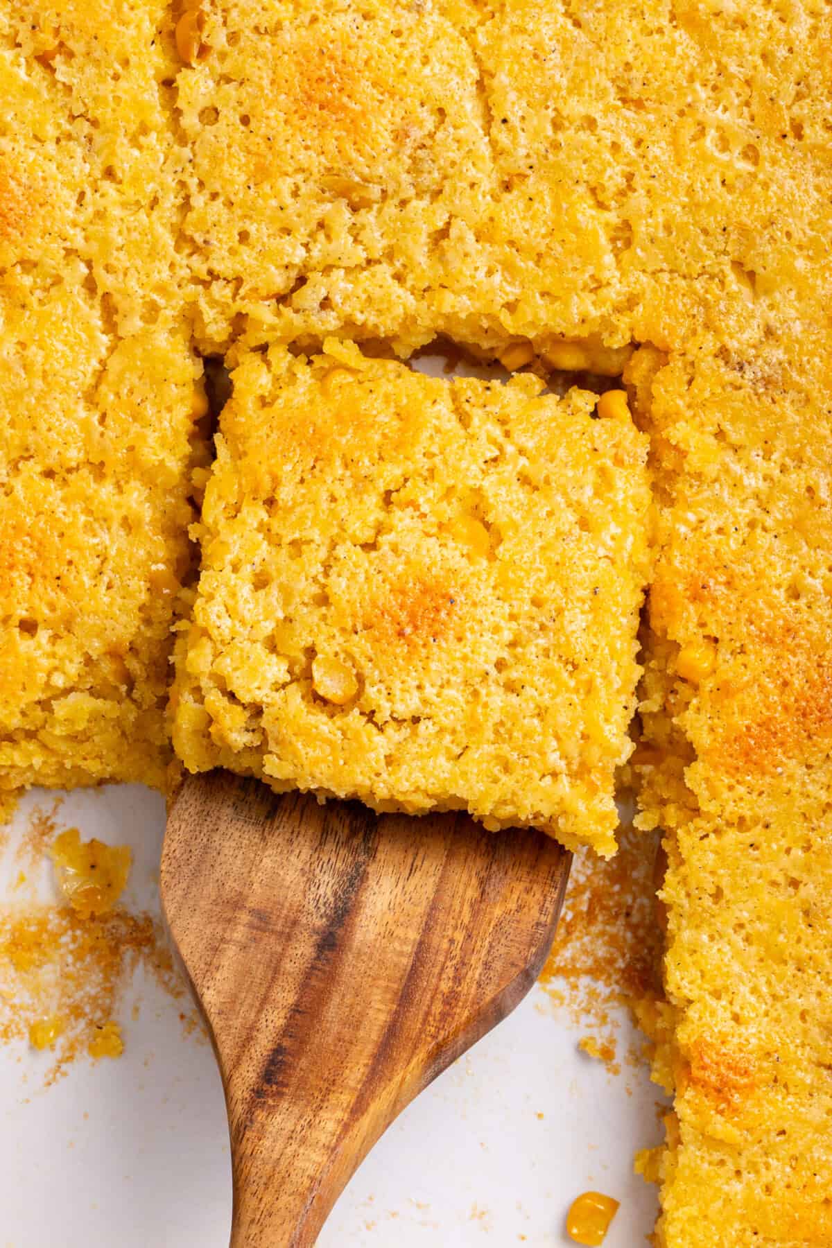 slice of corn souffle with a wooden spatula.