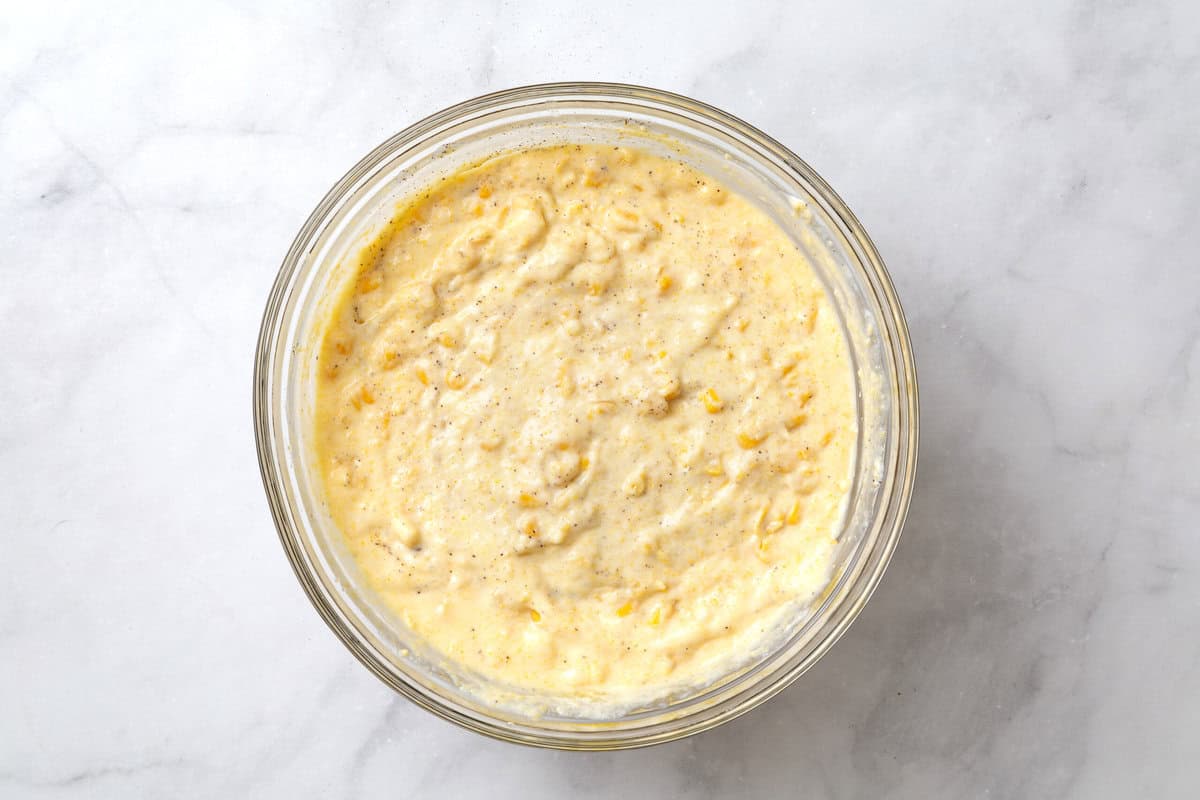 corn souffle batter in a glass bowl aerial view. 