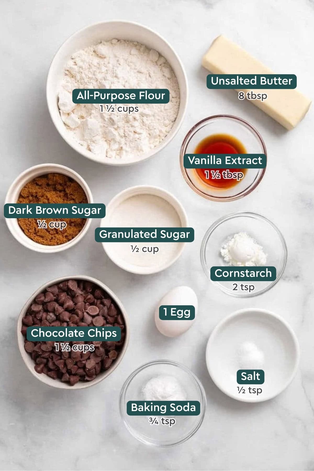 All of the ingredients for chocolate chip skillet cookie in bowls on a white countertop.