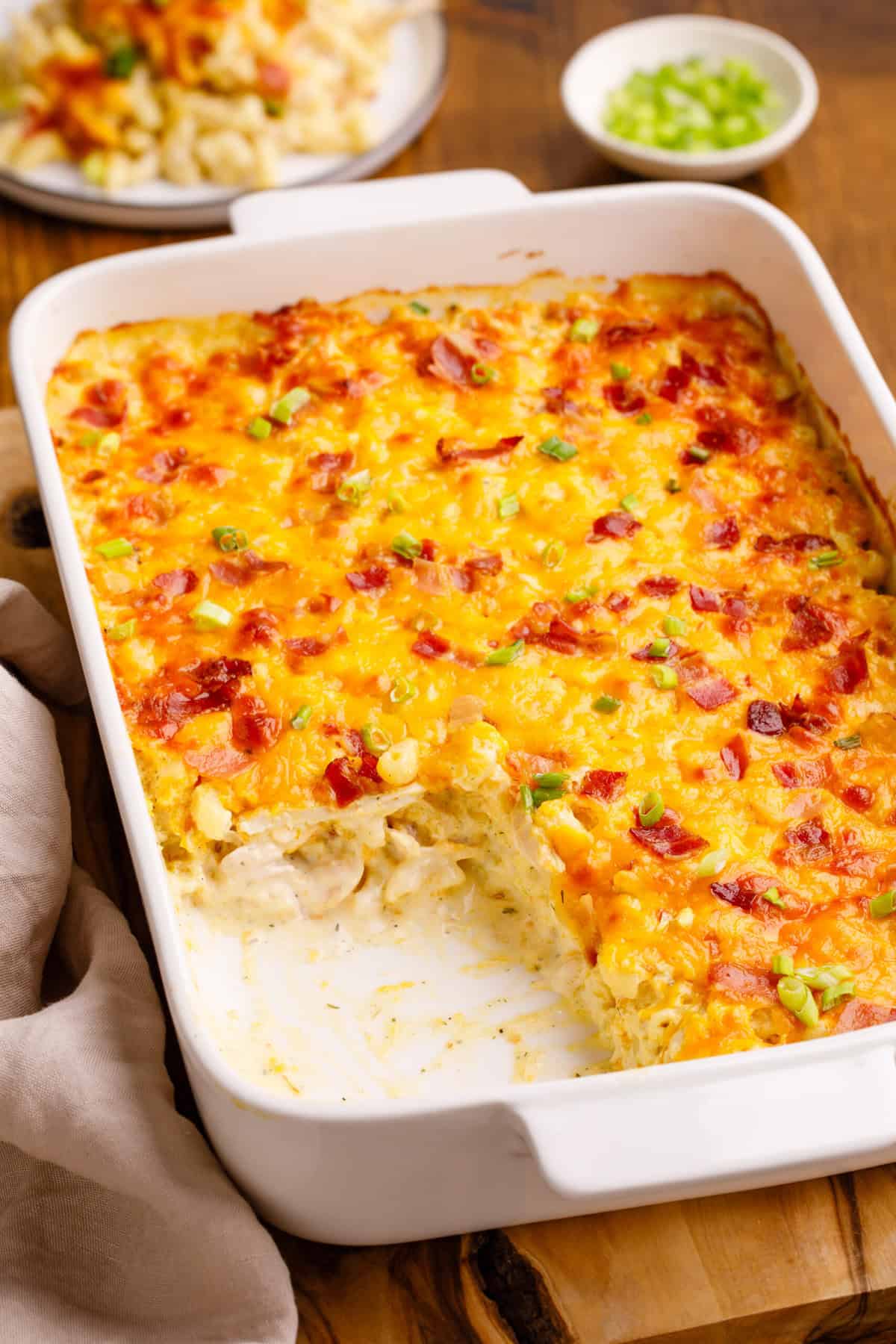 Crack chicken casserole in a baking dish with a serving taken out. 