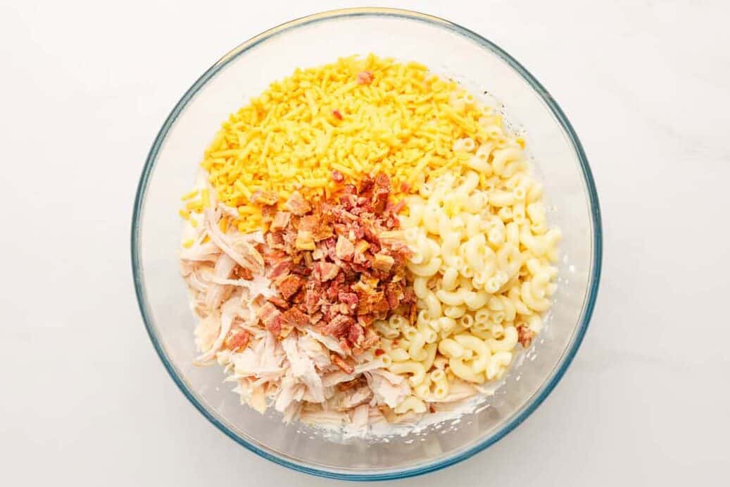 Chicken bacon, pasta, and cheese in a bowl. 