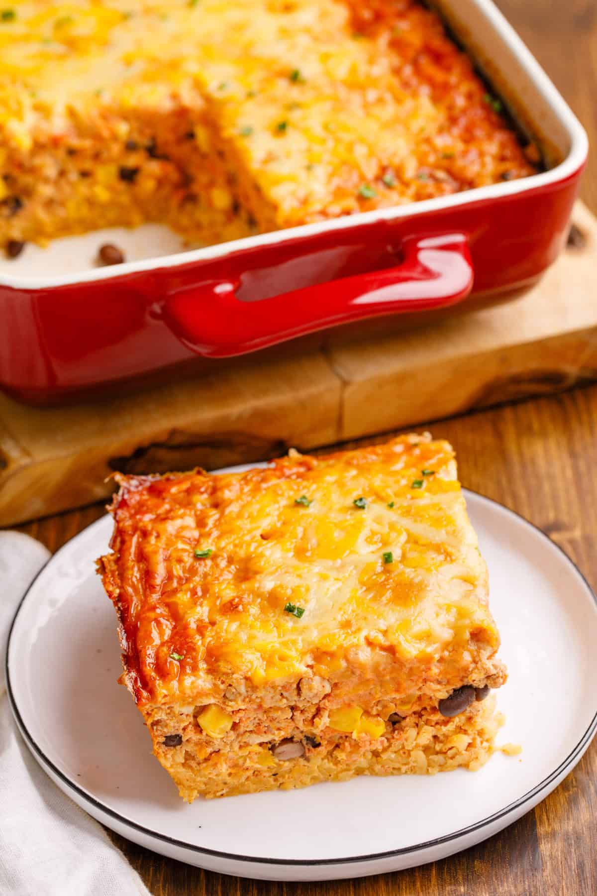 Mexican Breakfast Casserole Mexican Breakfast Casserole on a plate with more in the background in a baking dish.