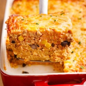 Mexican Breakfast Casserole on a serving spoon coming out of a baking dish.