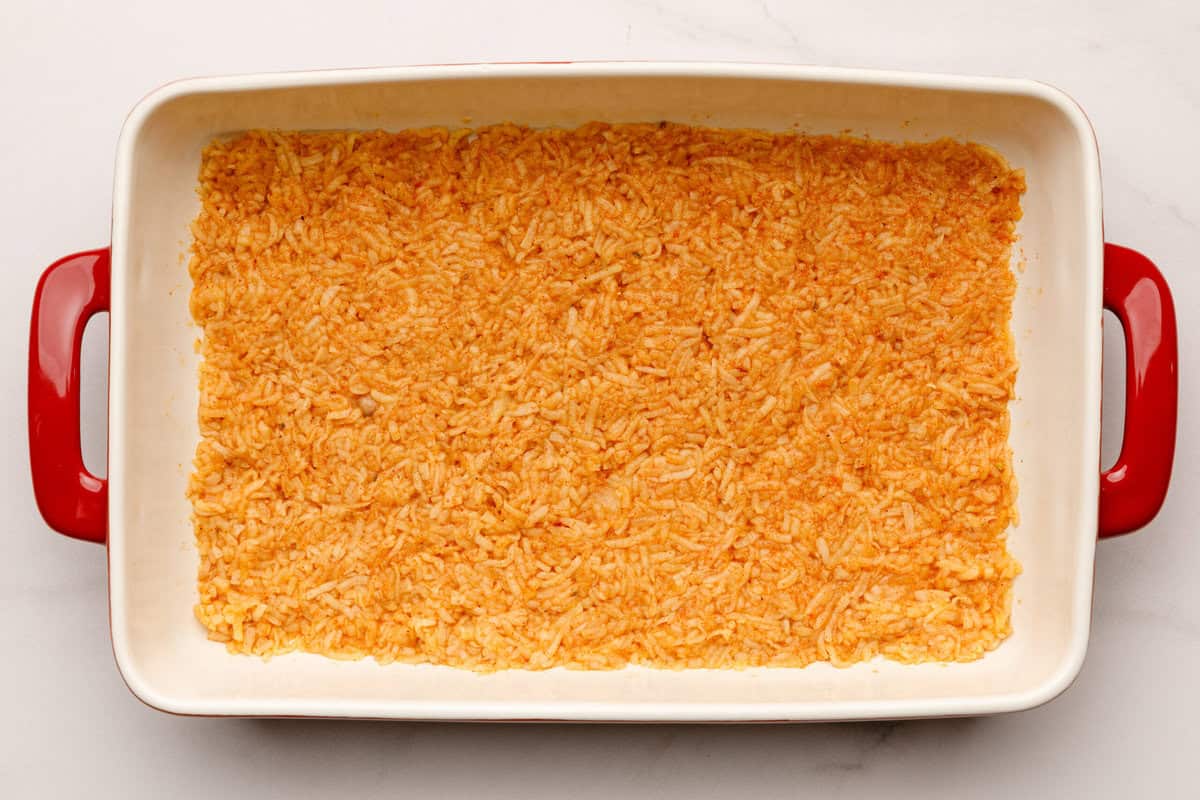 Mexican Breakfast Casserole Potatoes pressed down in a casserole baking dish.
