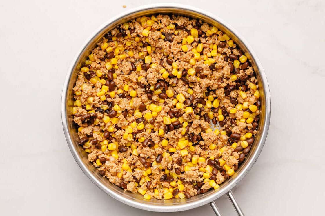 Mexican Breakfast Casserole Chorizo with black beans and corn cooking in a skillet.