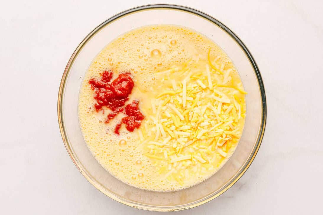 Mexican Breakfast Casserole Eggs, milk, cheese, salt, and pepper in a mixing bowl.