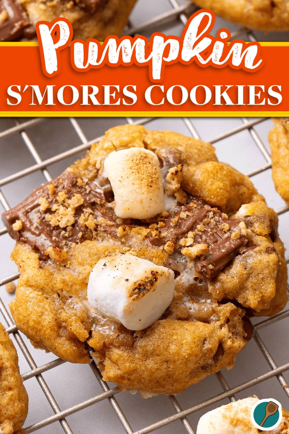 A close-up of a pumpkin s’mores cookie with gooey marshmallows, melted chocolate, and crushed graham cracker crumbs on a cooling rack.