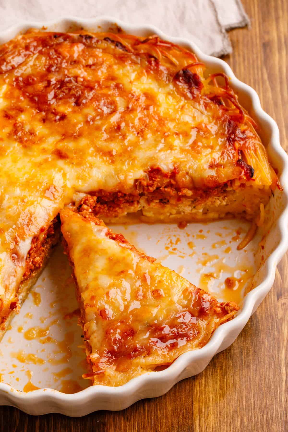 spaghetti pie slice in dish.