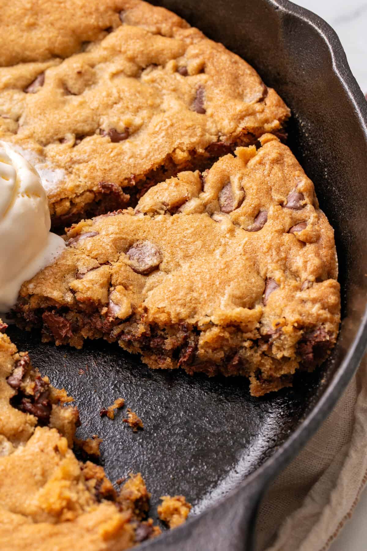 Chocolate chip cookie made in a cast iron skillet.