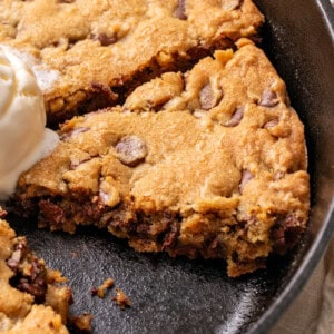 Chocolate chip cookie made in a cast iron skillet.