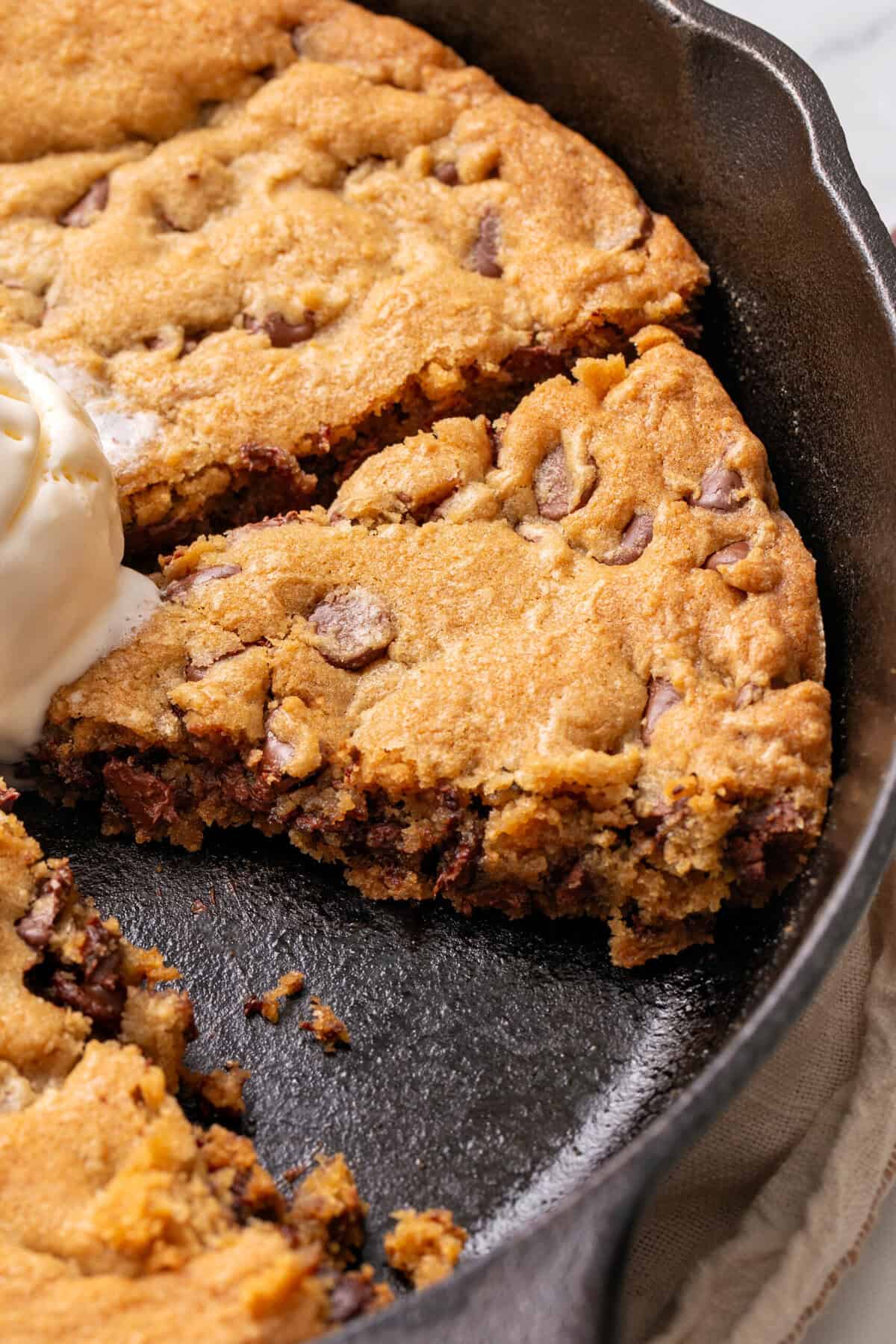 Chocolate chip cookie made in a cast iron skillet.