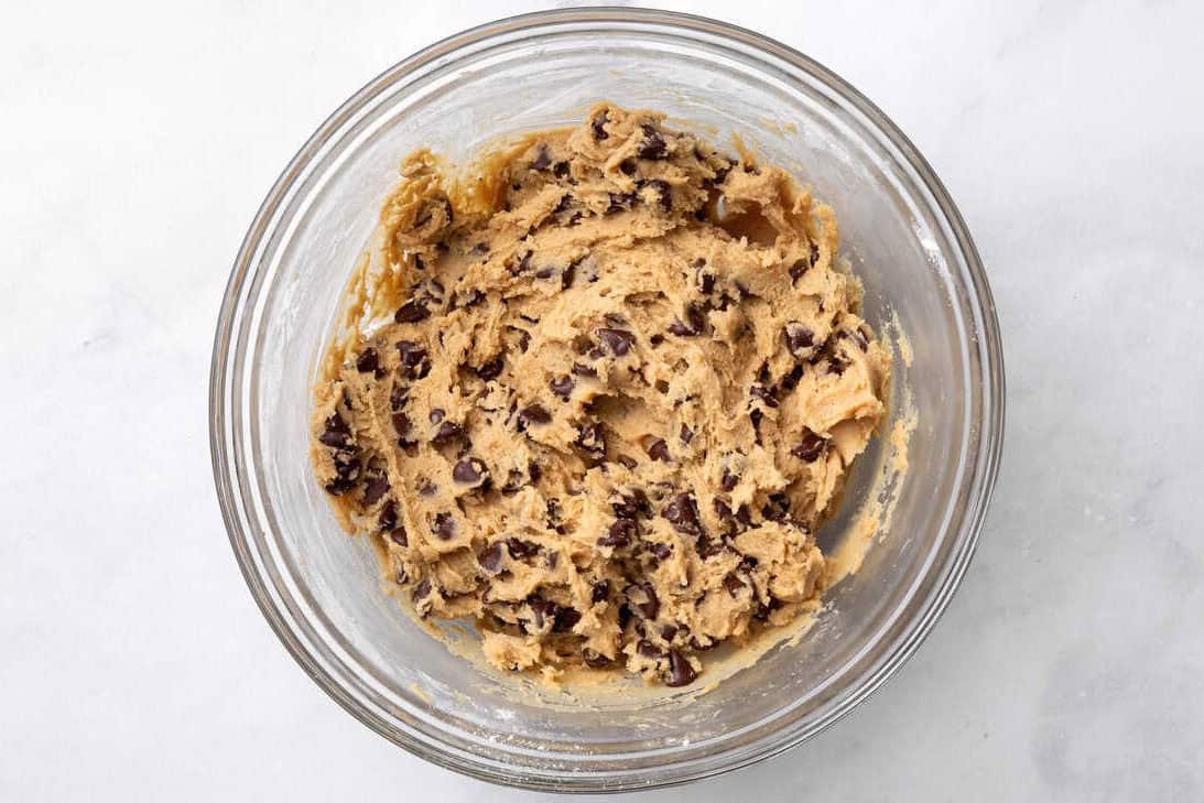 Chocolate chip skillet cookie dough in a glass bowl.
