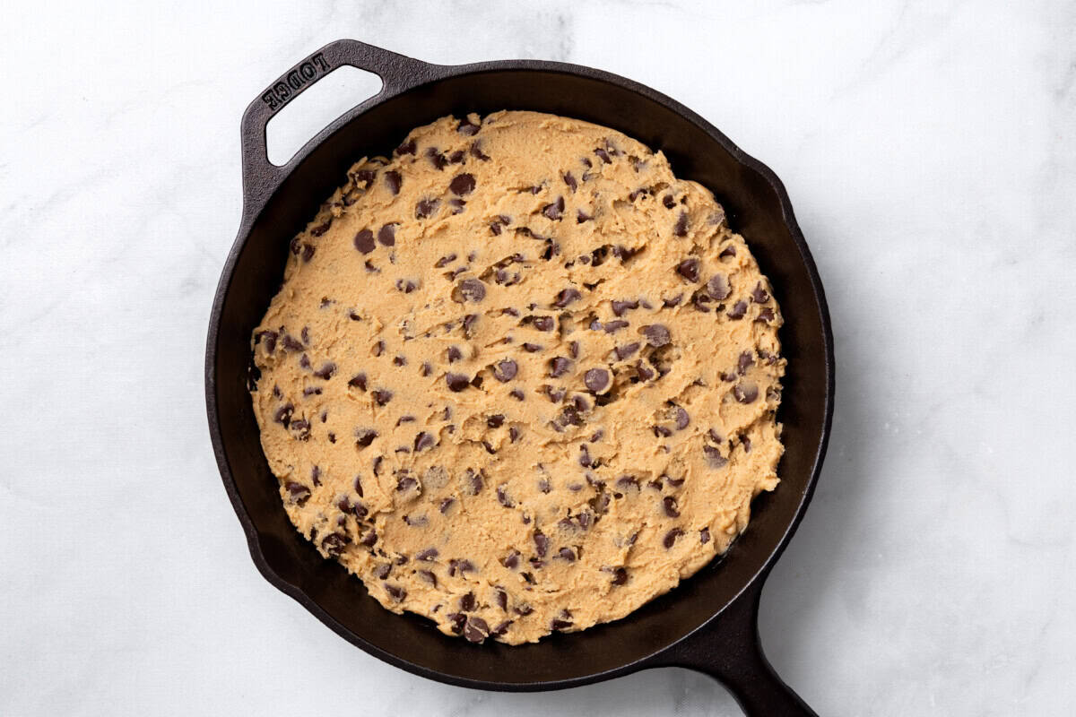 Choc chip cookie skillet dough in a cast iron pan. 