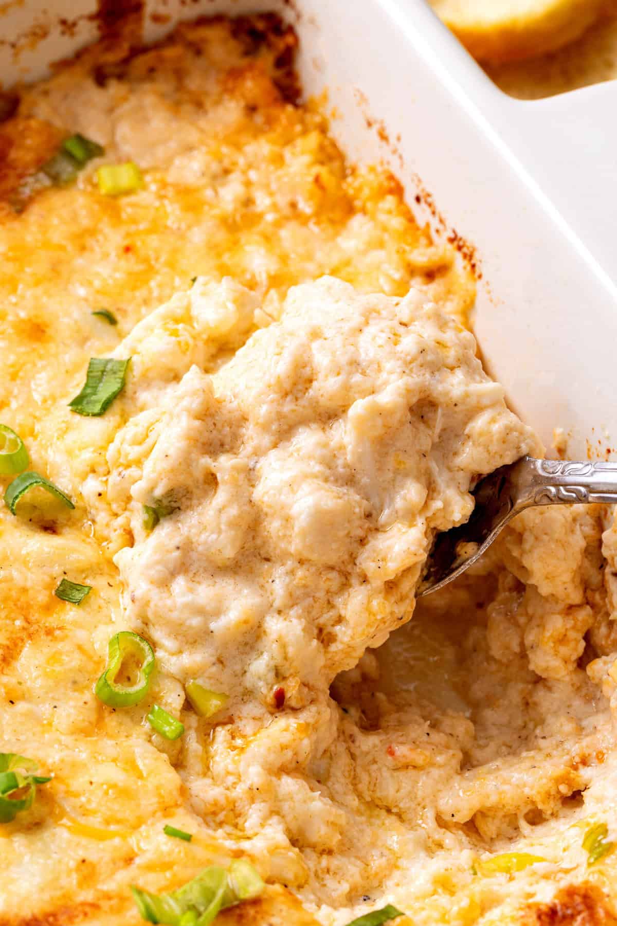 A close up of hot crab dip on a spoon. 