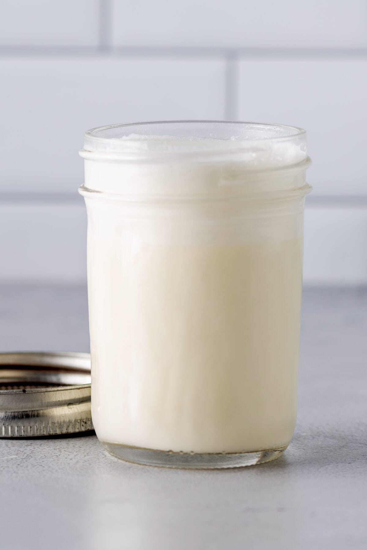 A glass jar with homemade heavy cream. 