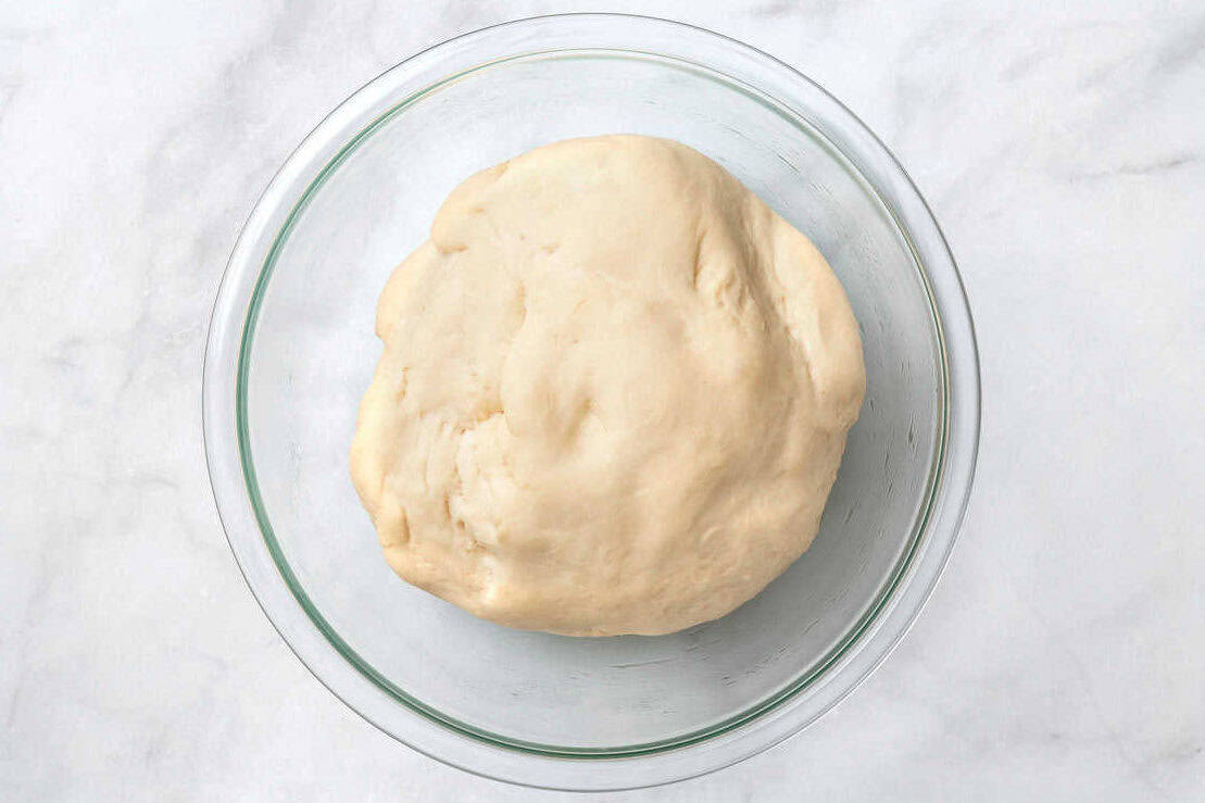 glass bowl full of roll dough. 