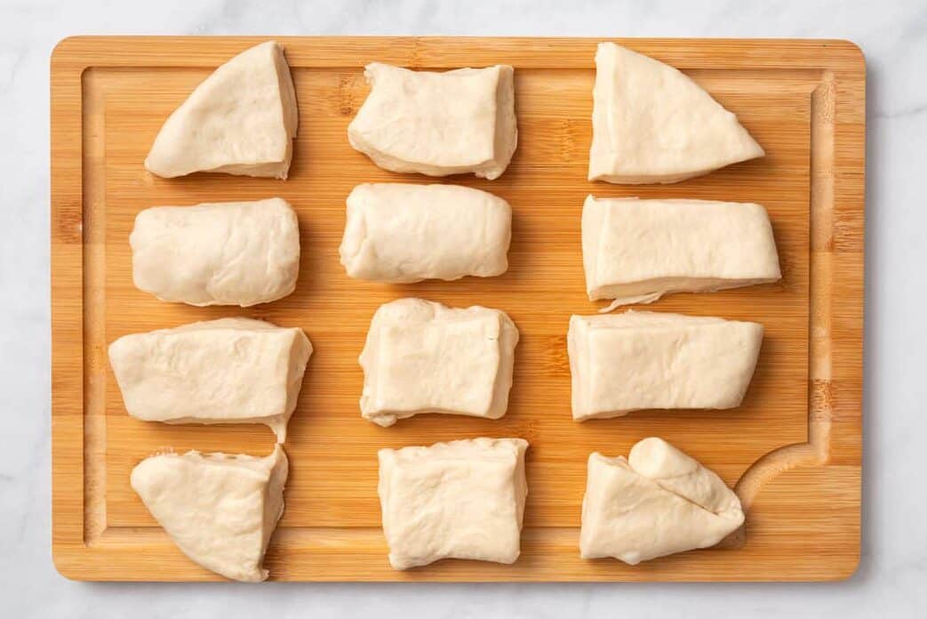 cutting the roll dough into pieces to make the individual rolls. 