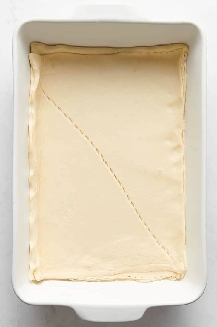 crescent roll dough lining a 9x12 casserole dish