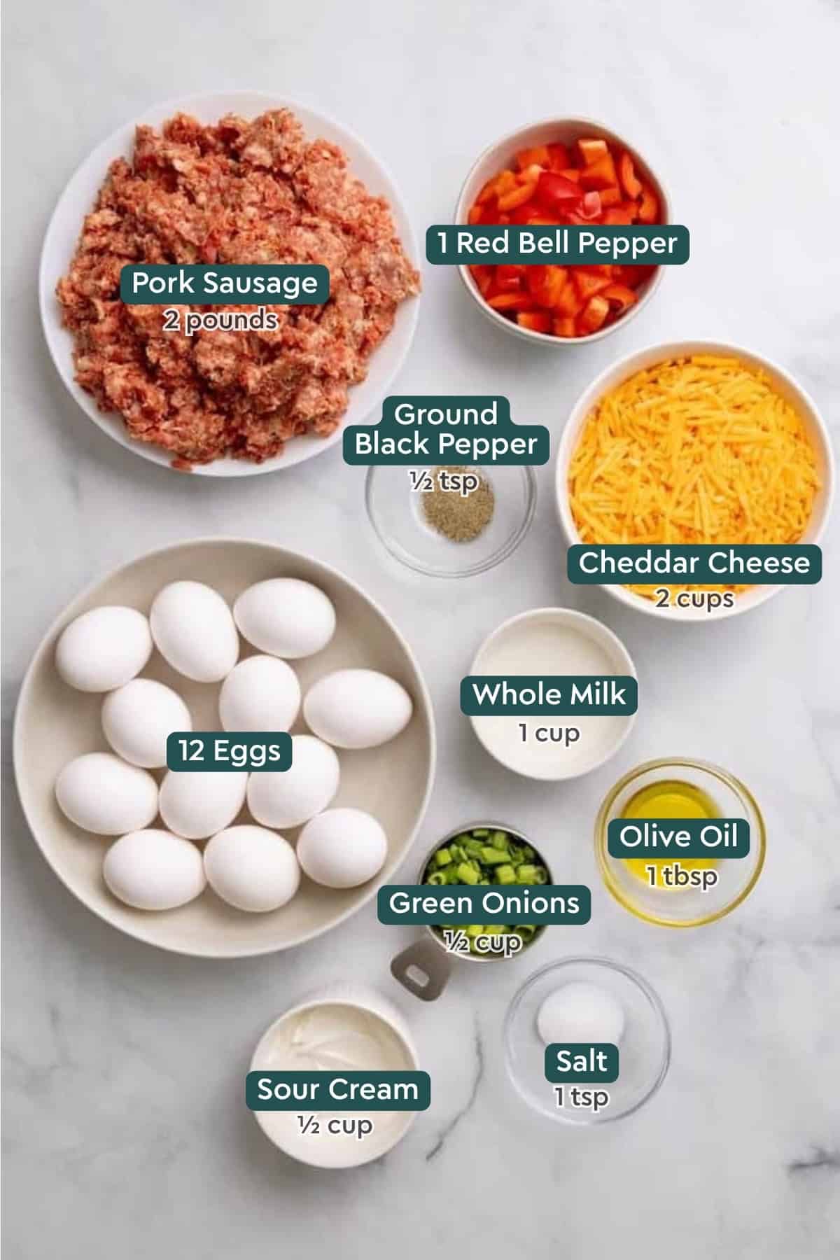 Ingredients for sausage breakfast casserole, including pork sausage, bell pepper, black pepper, cheddar, eggs, milk, oil, green onions, salt, and sour cream.