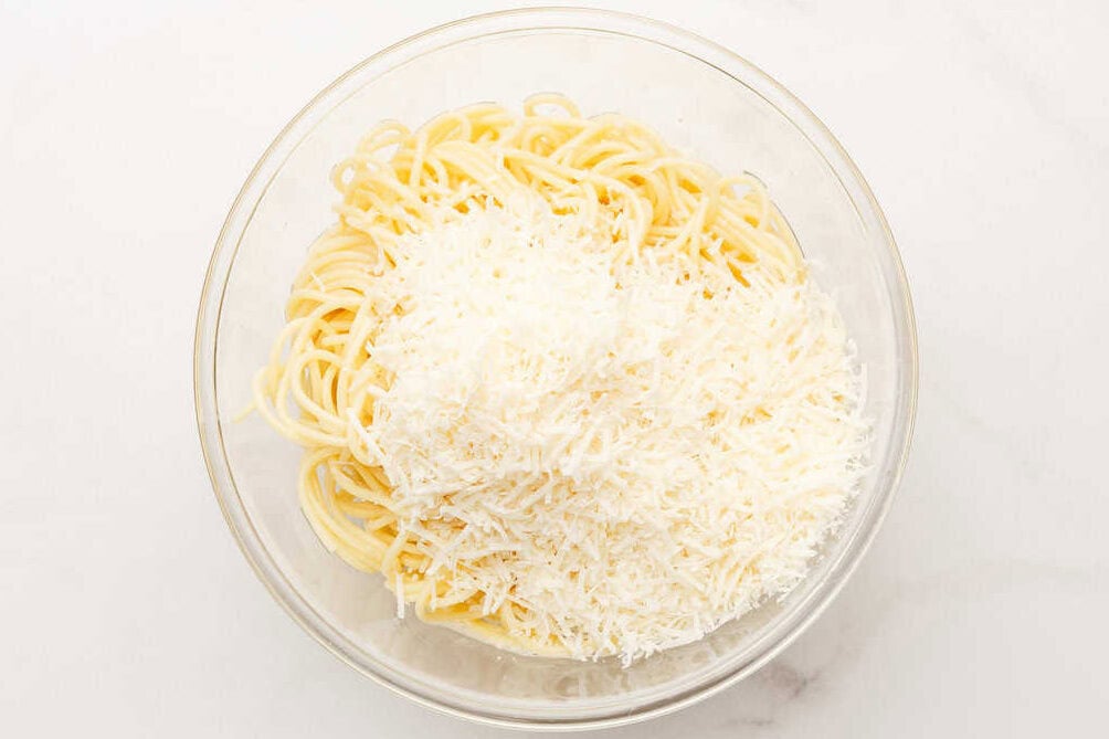 cheese and spaghetti in a bowl.