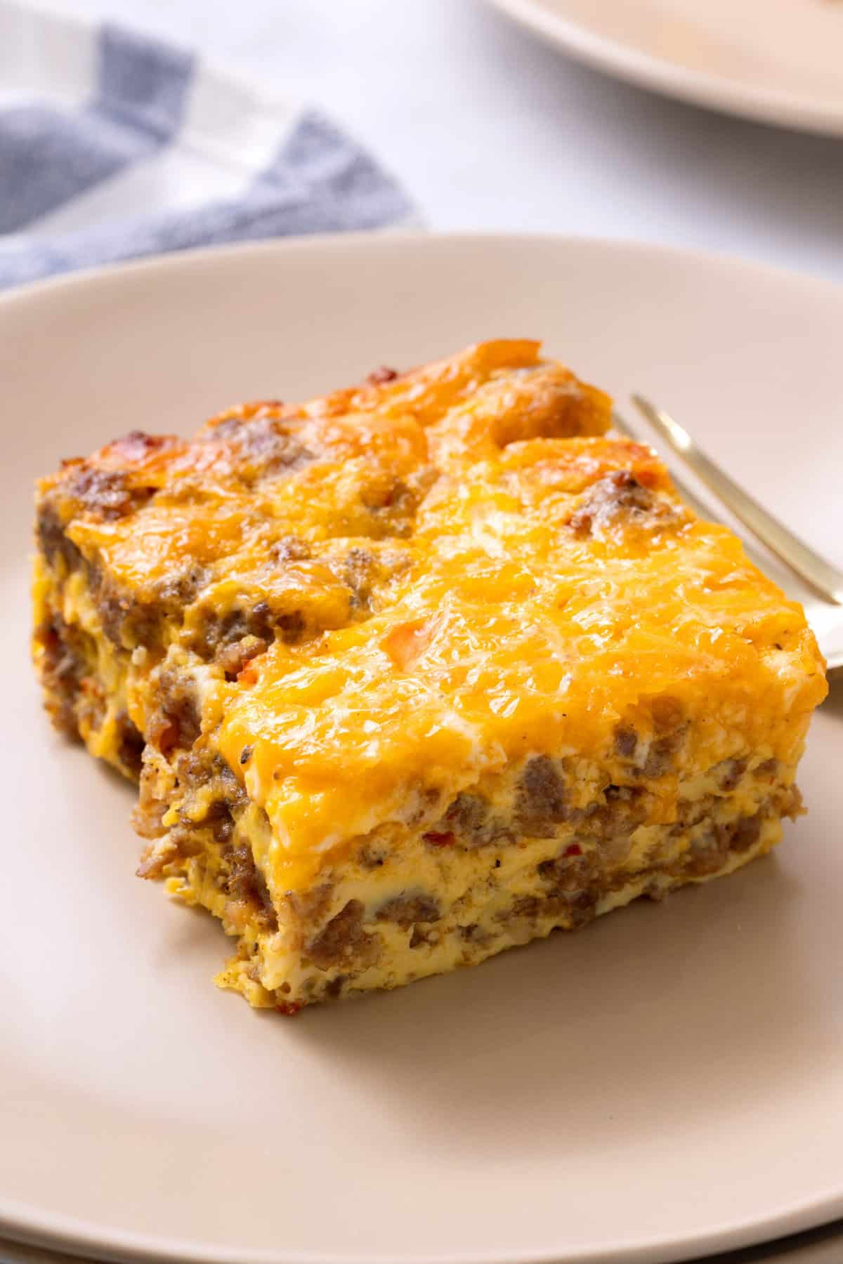 A slice of Sausage Breakfast Casserole on a white plate. 
