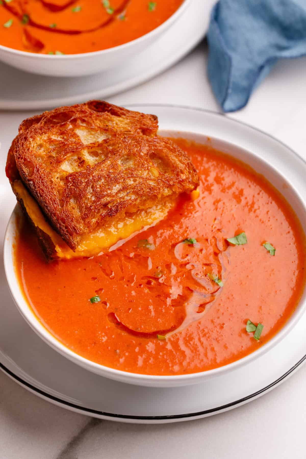 A Grilled Cheese Sandwich sitting in a bowl of soup. 
