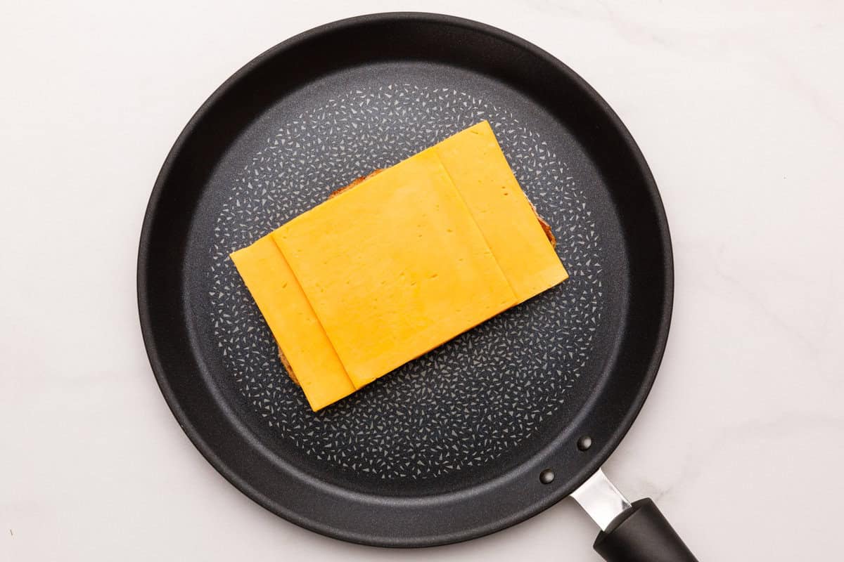 Cheese on top of bread in a non stick pan. 