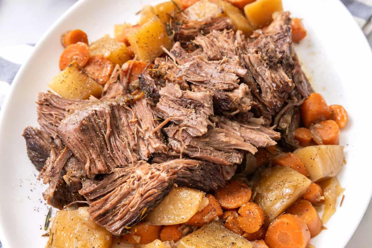 Dutch oven pot roast on a white plate.