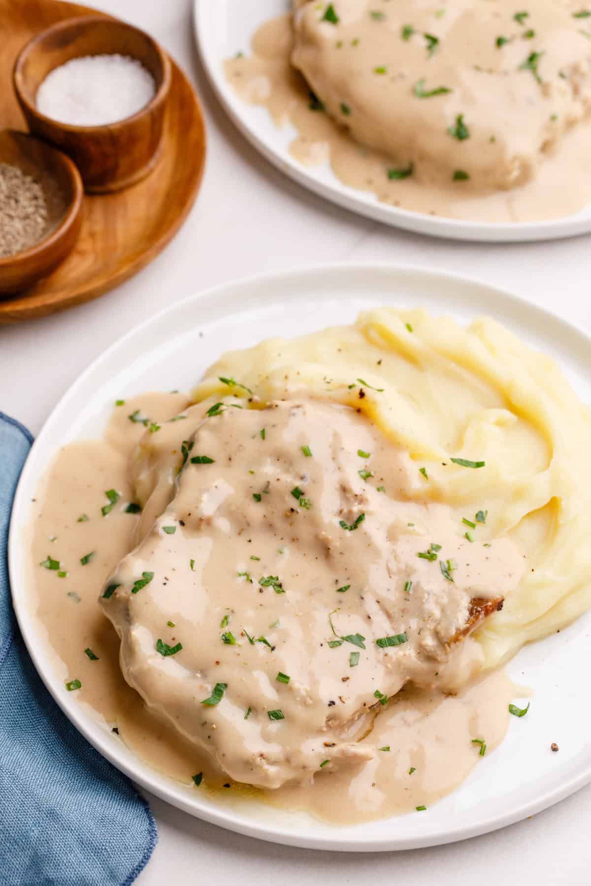 crockpot pork chops plate of pork chops and gravy with mashed potatoes.