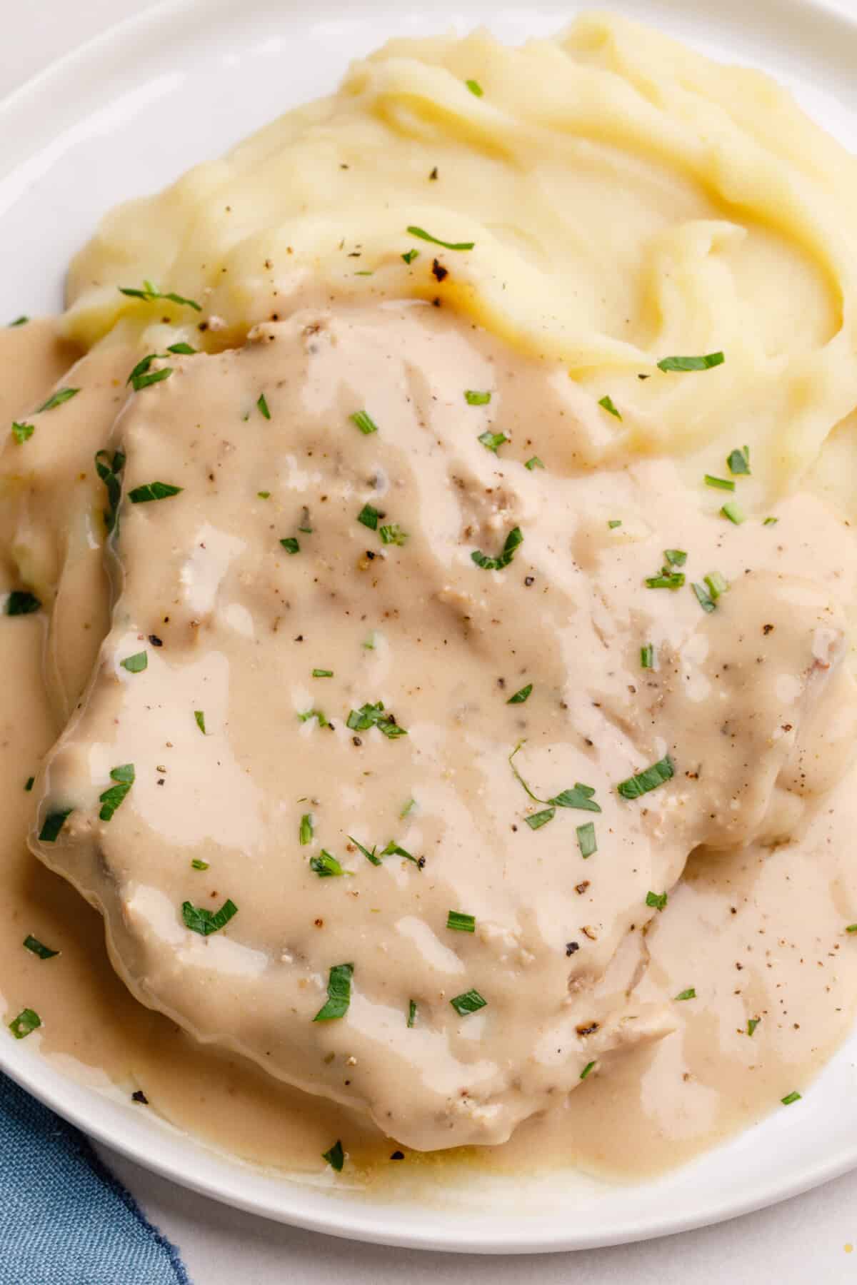 crockpot porkchops with gravy and fresh herbs.