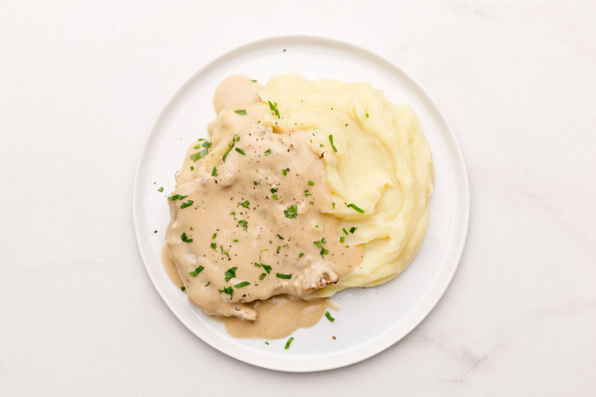 Plate of mashed potatoes and crockpot pork chops.