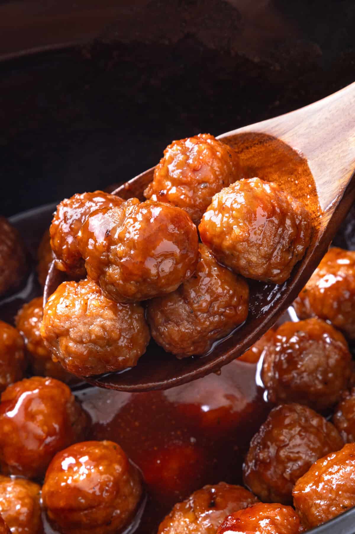 Grape jelly meatballs on a spoon.