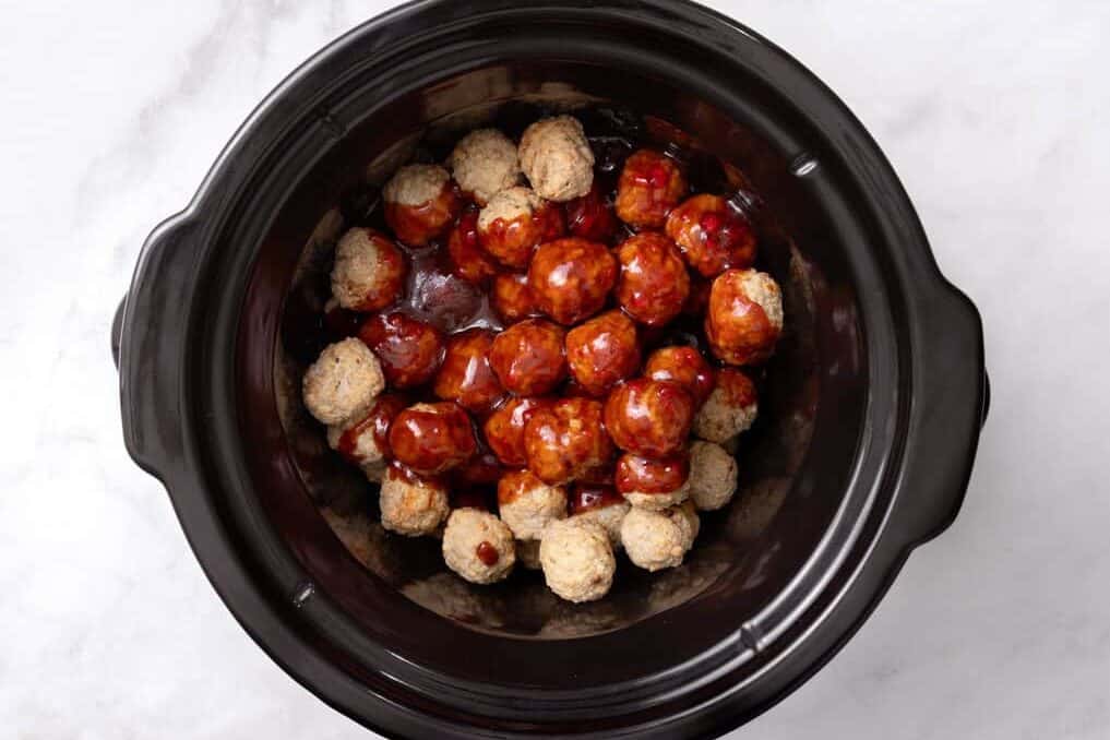 Frozen meatballs with sauce in slow cooker.